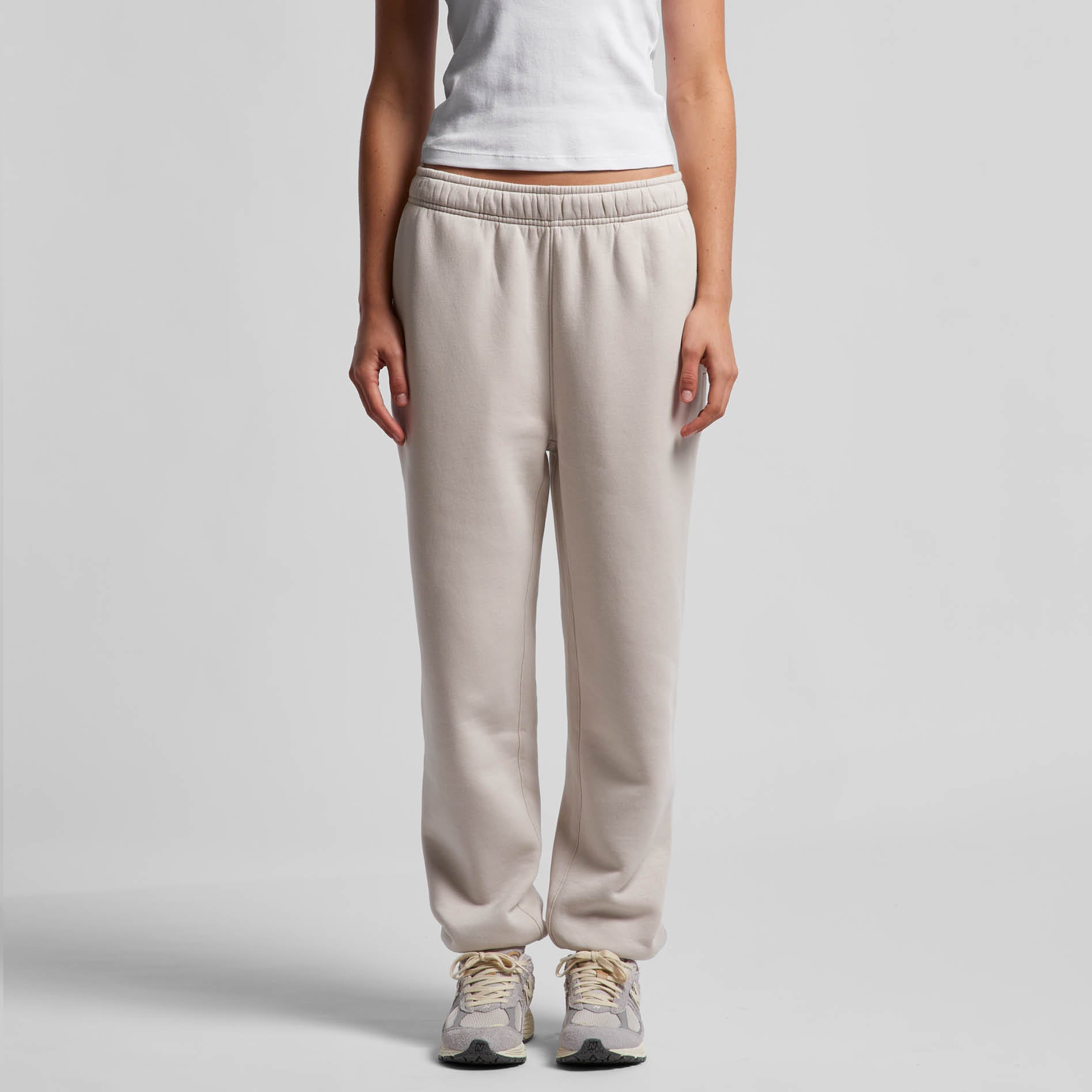 Person wearing bone coloured pants on a white background. Normalize Neurodivergence.