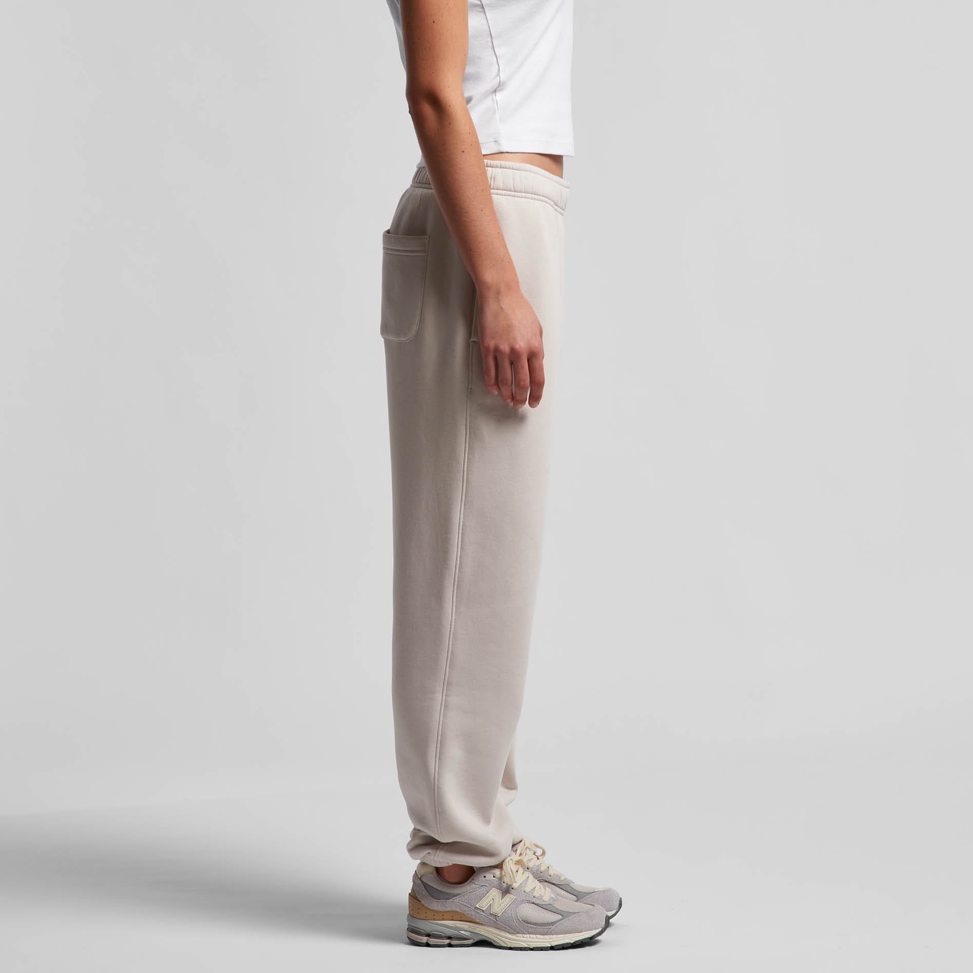 Person wearing bone coloured pants on a white background. Normalize Neurodivergence.