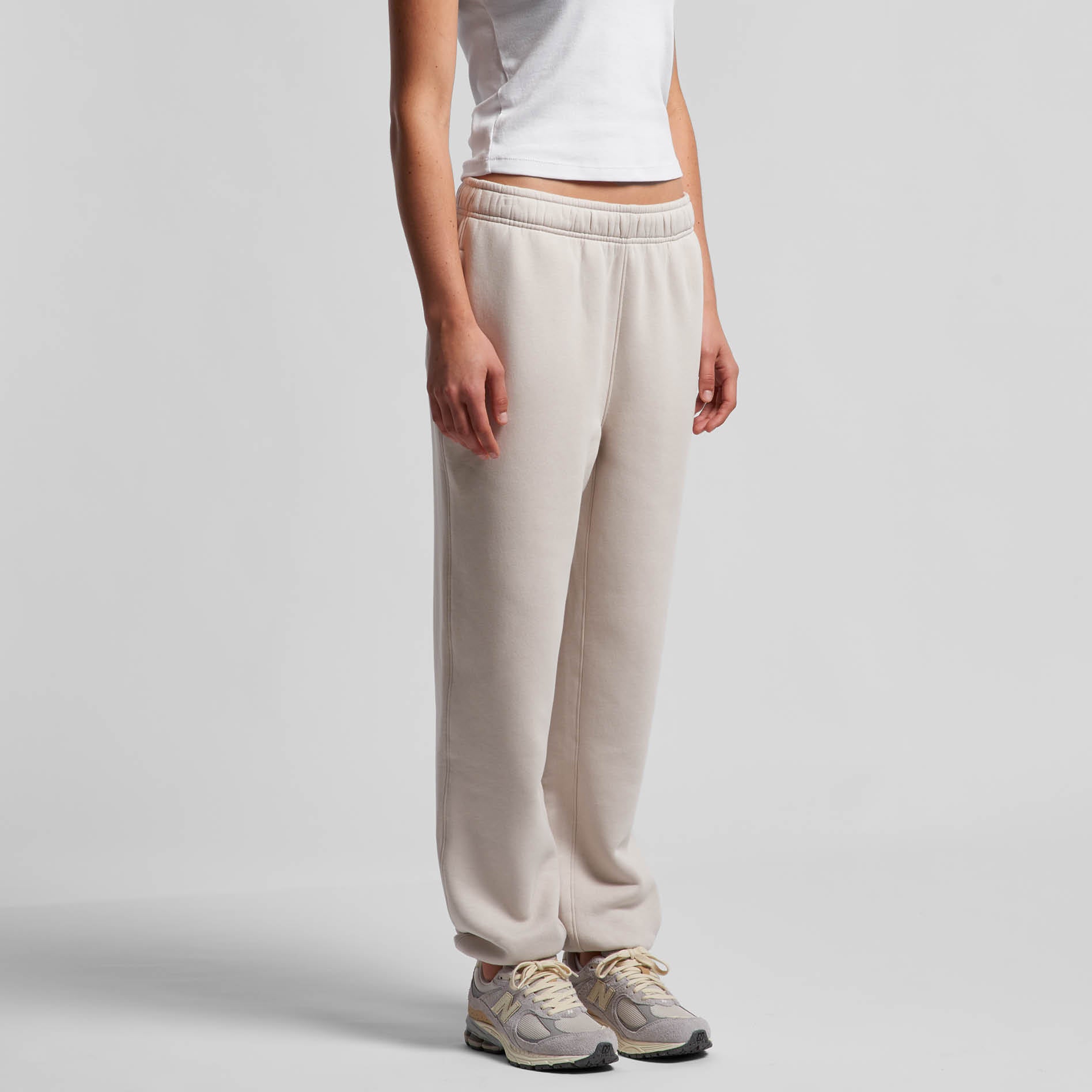 Person wearing bone coloured pants on a white background. Normalize Neurodivergence.