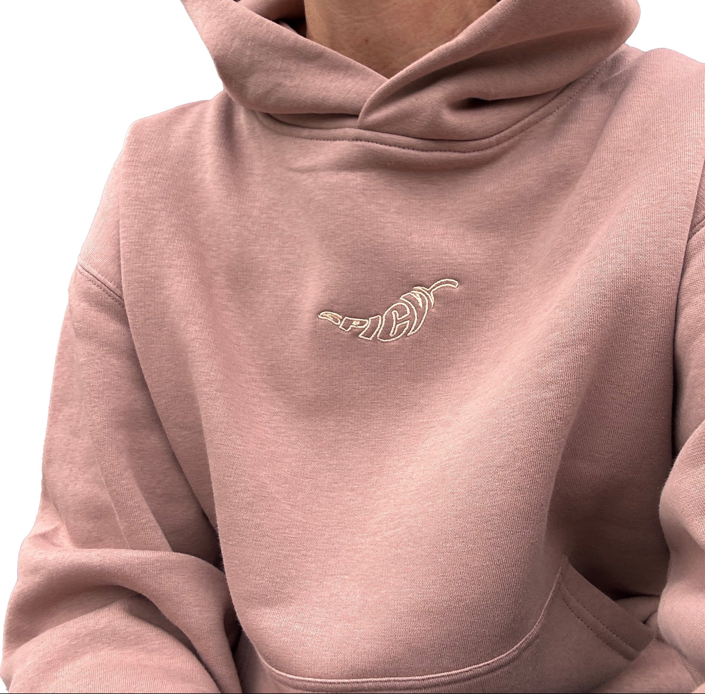 Hazy pink coloured hoodie with a embroidered spicy logo on a person. Normalize Neurodivergence.