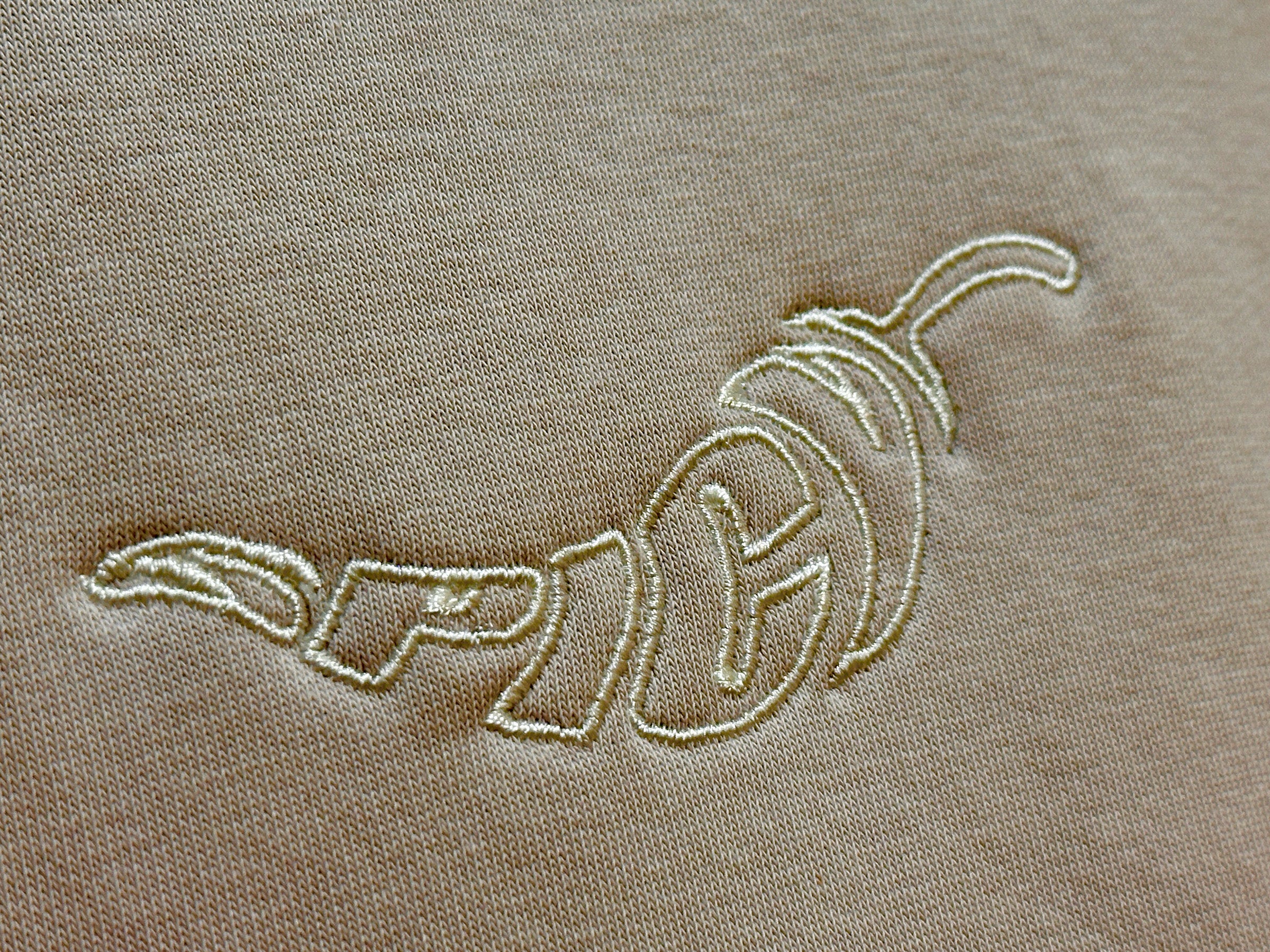 Embroidered spicy logo on a bone colored fabric. Normalize Neurodivergence Movement
